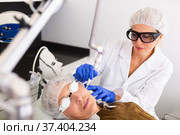 Female beautician making laser resurfacing of aged female client. Стоковое фото, фотограф Яков Филимонов / Фотобанк Лори