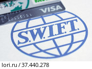 Банковские карты VISA, "Мир" на фоне логотипа SWIFT (2022 год). Редакционное фото, фотограф Гребенев Пётр / Фотобанк Лори
