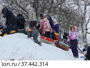 Дети с "ледянками" на снежной горке. Куча-мала. Проводы Масленицы в городе Александрове Владимирской области (2018 год). Редакционное фото, фотограф Елена Орлова / Фотобанк Лори