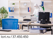 Old male contractor in office disinfection concept. Стоковое фото, фотограф Elnur / Фотобанк Лори