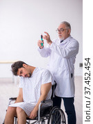 Old male doctor psychiatrist examining young disabled patient. Стоковое фото, фотограф Elnur / Фотобанк Лори