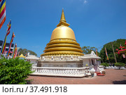 DAMBULLA, SRI LANKA - FEBRUARY 08, 2020: Golden Buddhist stupa close-up on a sunny day. Golden temple in Dambulla. Редакционное фото, фотограф Виктор Карасев / Фотобанк Лори