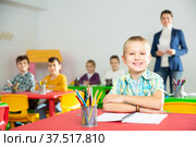 Smiling boy at pupils desk in school. Стоковое фото, фотограф Яков Филимонов / Фотобанк Лори