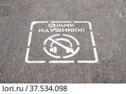 Предупредительная пиктограмма и надпись "Сними наушники" на асфальте перед пешеходным переходом в Самаре (2021 год). Стоковое фото, фотограф Ekaterina M / Фотобанк Лори