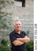 Elderly man with gray hair in black T-shirt near gray wall. Стоковое фото, фотограф Дарья Трофимова / Фотобанк Лори