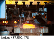Bearing plant. Stamping of outer ring of the bearing on mechanical press. Water cooling of the red-hot metal. Close up photo. Low depth of field. Ring in focus. Стоковое фото, фотограф Alexey Rezvykh / Фотобанк Лори