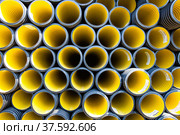 Plastic pipes production plant warehouse. Yellow PVC channelled pipes. Стоковое фото, фотограф Alexey Rezvykh / Фотобанк Лори