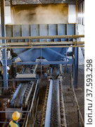 Phosphate fertilizers plant. Machine for pellets production. Conveyor transporter and worker. (2012 год). Редакционное фото, фотограф Alexey Rezvykh / Фотобанк Лори
