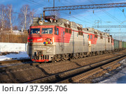 Электровоз ВЛ-80С в трехсекционном варианте с грузовым поездом крупным планом  солнечным мартовским днем. Северная железная дорога (2022 год). Редакционное фото, фотограф Виктор Карасев / Фотобанк Лори