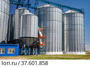 Modern metal grain elevator. Blue sky. Стоковое фото, фотограф Alexey Rezvykh / Фотобанк Лори