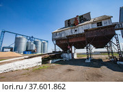 Old outdated Soviet grain storage (right) and modern steel elevator silos (left). Стоковое фото, фотограф Alexey Rezvykh / Фотобанк Лори