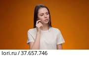 Blonde woman thinking over smart idea, pondering, against yellow background. Стоковое видео, видеограф Сергей Толмачёв / Фотобанк Лори