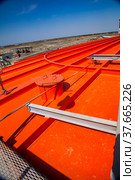 Orange metal tanks with acid at sulphuric acid plant warehouse. Стоковое фото, фотограф Alexey Rezvykh / Фотобанк Лори