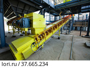 Kzylorda region/Kazakhstan - April 30 2012: Sulphuric acid plant. Yellow belt conveyor (transporter) on plant warehouse. Sulfur storage. Редакционное фото, фотограф Alexey Rezvykh / Фотобанк Лори