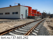 Kzylorda region/Kazakhstan - April 30 2012: Orange steel storage tanks with acid at (sulphuric) acid plant warehouse. Cargo railway terminal. Filling station. On the blue sky background. Редакционное фото, фотограф Alexey Rezvykh / Фотобанк Лори