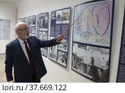 Военный эксперт Юрий Альбертович Кнутов проводит экскурсию по выставке в Балашихинской картинной галерее (2022 год). Редакционное фото, фотограф Дмитрий Неумоин / Фотобанк Лори