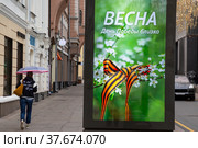 Рекламный баннер с надписью "Весна. День Победы близко" установлен на улице Большая Дмитровка в центре города Москвы, Россия (2022 год). Редакционное фото, фотограф Николай Винокуров / Фотобанк Лори