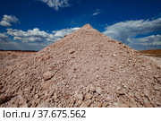 Pyramid heap of spoil. Aluminium ore mining. Bauxite clay quarry on blue sky with clouds. Стоковое фото, фотограф Alexey Rezvykh / Фотобанк Лори