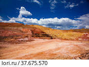 Aluminium ore quarry. Bauxite clay open-cut mining. Quarry steps of color minerals. Deep blue sky and white clouds. Стоковое фото, фотограф Alexey Rezvykh / Фотобанк Лори