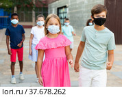 Pair of young people in masks walking hand in hand. Стоковое фото, фотограф Яков Филимонов / Фотобанк Лори