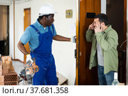 Flatmate is dissatisfied with the noise from drill and repairs. Стоковое фото, фотограф Яков Филимонов / Фотобанк Лори