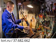 Gunsmith examines and checks appearance of the semi automatic rifle. Стоковое фото, фотограф Яков Филимонов / Фотобанк Лори