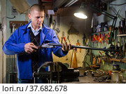 Double-barreled hunting rifle in hands of gunsmith in weapons workshop. Стоковое фото, фотограф Яков Филимонов / Фотобанк Лори