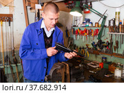 Gunsmith assembling smallbore sporting pistol in workshop. Стоковое фото, фотограф Яков Филимонов / Фотобанк Лори
