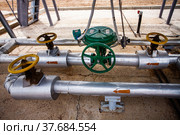 Uralsk region, Kazakhstan - May 24 2012: Oil deposit Zhaikmunai. Oil refinery plant in desert. Close-up photo of refinery equipment. Valve armature and pipes. Стоковое фото, фотограф Alexey Rezvykh / Фотобанк Лори
