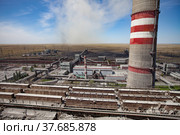 GRES-1 steam power station. Panorama, aerial. Metal constructions on foreground and smoke stack. Coal-plows loads coal on conveyor belt to plant. Стоковое фото, фотограф Alexey Rezvykh / Фотобанк Лори