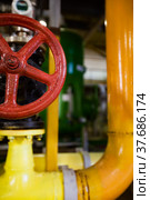 Close-up of yellow pipe and red valve armature. Abstract background on chemical plant. Short depth of field. Стоковое фото, фотограф Alexey Rezvykh / Фотобанк Лори