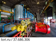 Aksu, Pavlodar region, Kazakhstan - May 29, 2012: Aksu steam power station workshop. Red cones of fire extinguisher system. Grey tanks with blue pipes on background. Редакционное фото, фотограф Alexey Rezvykh / Фотобанк Лори