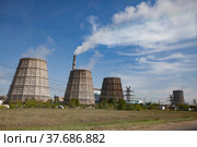 Pavlodar thermal electric station. Cooling towers and smoke stack with white smoke. Green grass, blue sky with clouds. Стоковое фото, фотограф Alexey Rezvykh / Фотобанк Лори