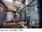 Almaty region, Kazakhstan-June 04,2012:Extraction of gold ore.Mining and processing plant of Altynalmas company.Stainless steel chemical reactor.Sodium cyanide NaCN production.Worker right. Редакционное фото, фотограф Alexey Rezvykh / Фотобанк Лори