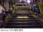 Temirtau, Kazakhstan - June 09, 2012: Concrete sleepers manufacturing plant NORD Prom NS. Workers and vibration line machine. Редакционное фото, фотограф Alexey Rezvykh / Фотобанк Лори