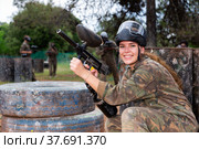 Paintball players of one team in camouflages and masks aiming with gun in shootout playing. Стоковое фото, фотограф Яков Филимонов / Фотобанк Лори