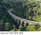 Sri Lanka. The attraction is the ancient railway Nine-arch Demodara Bridge in the midst of a dense tropical forest. Shooting from the air on a drone. Sunny day, sunset. Стоковое фото, фотограф Yuriy Savin / Фотобанк Лори