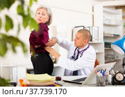 Therapist examining female patient complaining of low back pain. Стоковое фото, фотограф Яков Филимонов / Фотобанк Лори