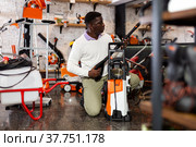 Considerate customer chooses washer at garden tool store. Стоковое фото, фотограф Яков Филимонов / Фотобанк Лори