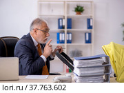 Old male employee looking after new born at workplace. Стоковое фото, фотограф Elnur / Фотобанк Лори