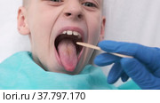 Boy opens her mouth wide and pulls out long tongue. child shows his teeth soft palate and mouth to dentist. mouth is wide open, tongue is stuck out as far as possible, with clear view of tongue. Стоковое видео, видеограф Ирина Ткачук / Фотобанк Лори