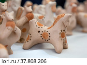 Плешковская глиняная игрушка лежит на прилавке на фестивале народного творчества в городе Туле, Россия (2022 год). Редакционное фото, фотограф Николай Винокуров / Фотобанк Лори