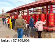 Люди крутят молитвенные барабаны у буддийского храма "Золотая обитель Будды Шакьямуни". Элиста. Республика Калмыкия. Россия (2022 год). Редакционное фото, фотограф Сергей Афанасьев / Фотобанк Лори