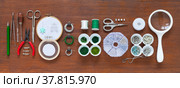 Accessories for embroidery brooches with beads, rhinestones and gimps. Tools and sets of green and white beads in containers on wooden table. Fashion hobby. DIY concept. Banner, flat lay, closeup, top view. Стоковое фото, фотограф Виктория Катьянова / Фотобанк Лори