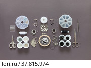 Fashionable hobby - embroidery of brooches with beads. Process of embroidering a brooch in form of black and white symbol of yin and yang with beads, bugle, rhinestones, gimp and chains on gray table. Стоковое фото, фотограф Виктория Катьянова / Фотобанк Лори