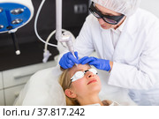 Professional beautician making laser resurfacing to female client face skin. Стоковое фото, фотограф Яков Филимонов / Фотобанк Лори