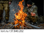 Солдат греется у костра (2021 год). Редакционное фото, фотограф Виталий Михайлюк / Фотобанк Лори