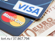 Банковские карты Visa card и MasterCard на фоне банкнот Евро (2014 год). Редакционное фото, фотограф Александр Гаценко / Фотобанк Лори