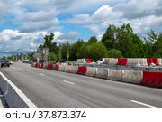 Moscow, Russia - June 05. 2022. Water-filled barriers stand along the road during repairs. Редакционное фото, фотограф Володина Ольга / Фотобанк Лори