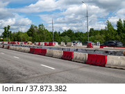 Moscow, Russia - June 05. 2022. Water-filled barriers stand along the road during repairs. Редакционное фото, фотограф Володина Ольга / Фотобанк Лори